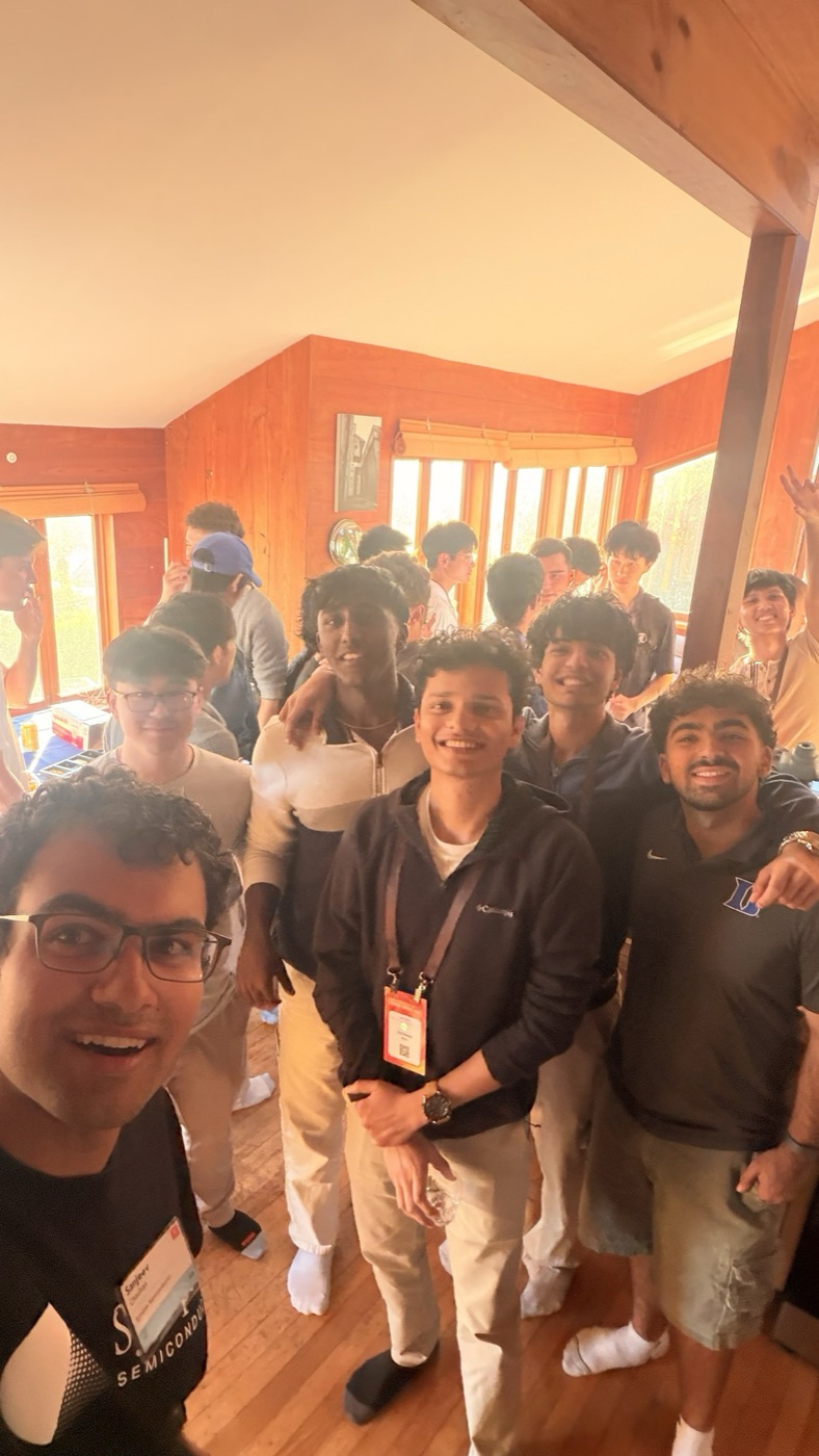Group selfie at a house party, badges on