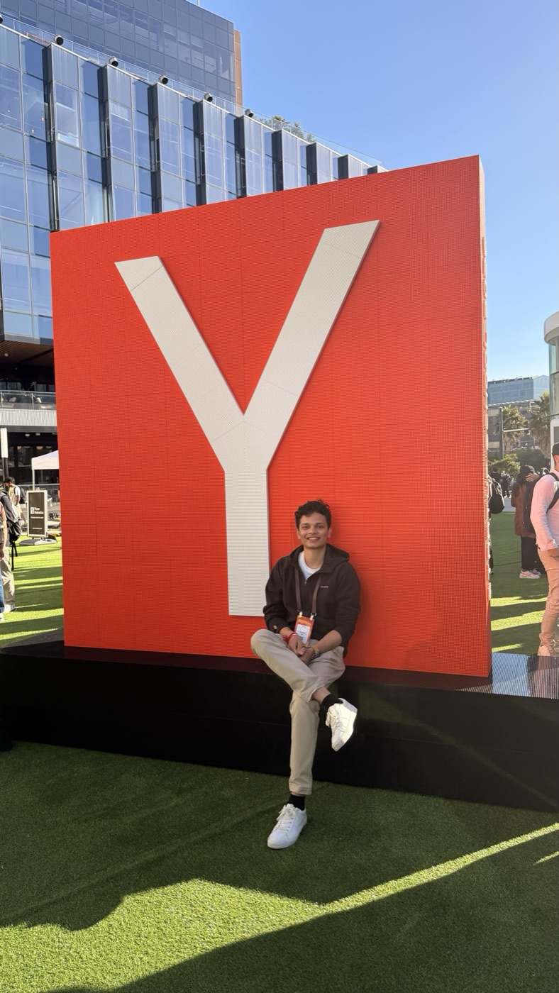Jaideep sitting in front of the giant red Y sculpture outside Chase Center